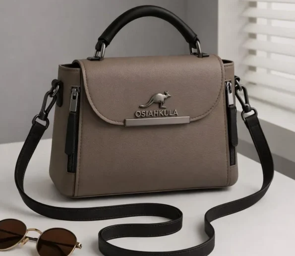 Taupe women’s handbag with black top handle and adjustable shoulder strap