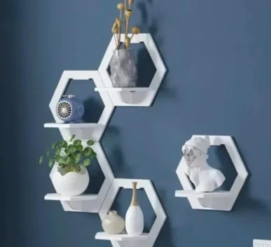 Modern white hexagon wall shelves with decorative vases, plant, fan, and sculpture
