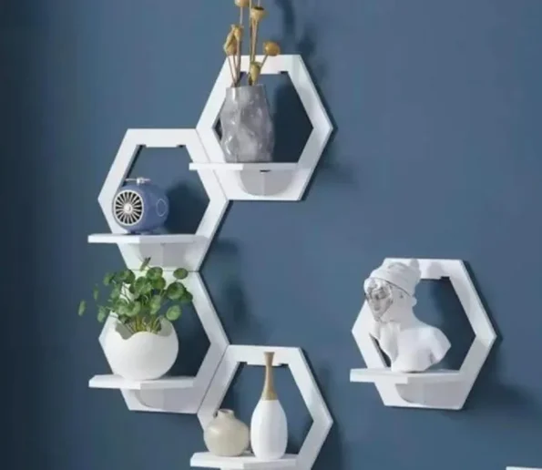 Modern white hexagon wall shelves with decorative vases, plant, fan, and sculpture