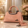 Elegant pink women’s handbag with dual handles, textured finish, and adjustable shoulder strap.