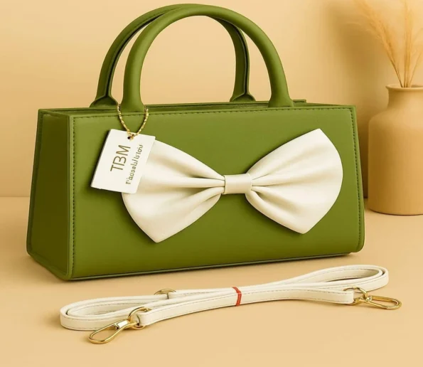 Green handbag with white bow and shoulder strap