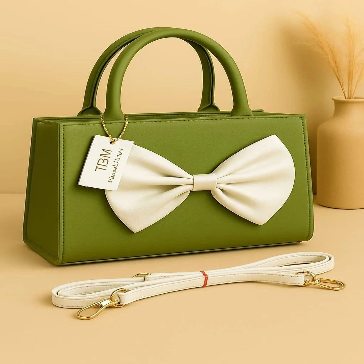 Green handbag with white bow and shoulder strap