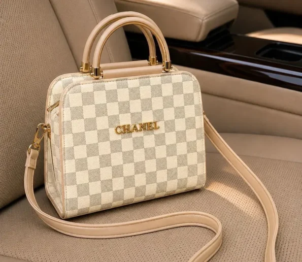 Beige checkered women’s handbag with shoulder strap on car seat