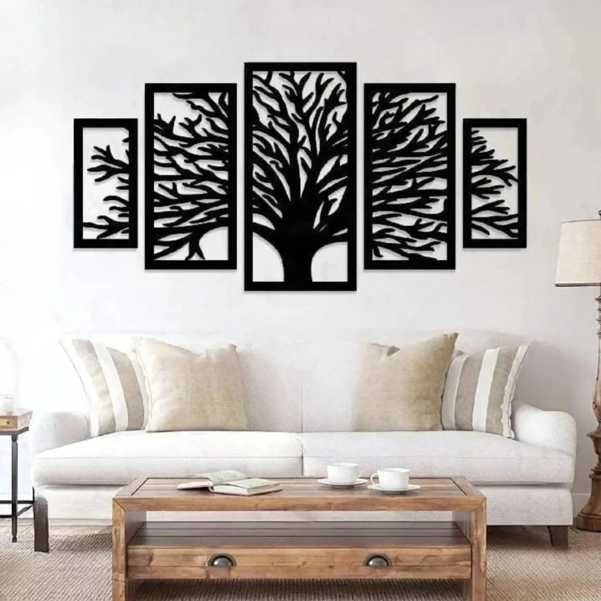 Black tree of life wall art in five-panel design above a white sofa