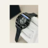 Black luxury skeleton watch with a detailed mechanical dial, rubber strap, and white glove against a beige background.